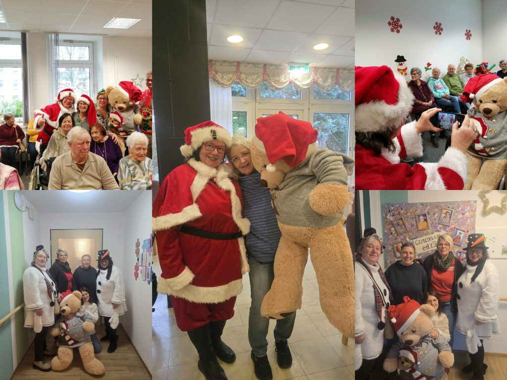Personen in Weihnachtskostümen und Teddybären bei einer festlichen Veranstaltung in einem Innenraum.